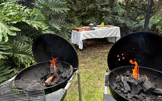 Dos asadores encendidos en el jardín de un evento