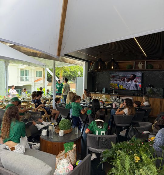 Invitados conviviendo bajo un toldo con el montaje al frente