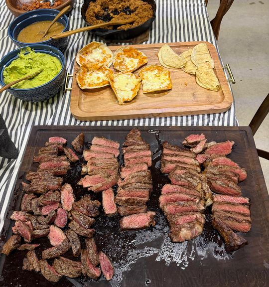 Tabla con cortes rebanados, guacamole, frijoles y quesadillas