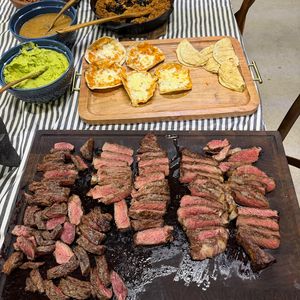 Quesadillas doradas junto a una tabla de cortes y frijoles puercos