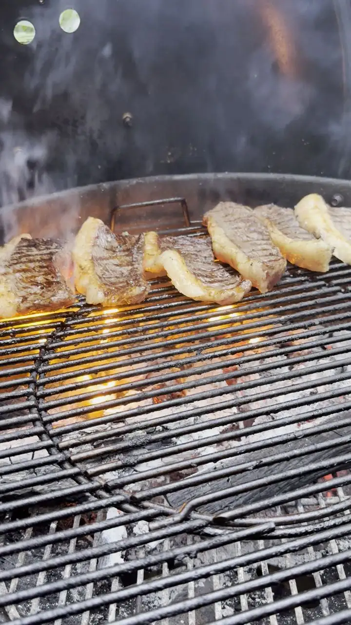 Parrillero de CopaFire cocinando cortes sobre la parrilla en el jardín de un evento privado